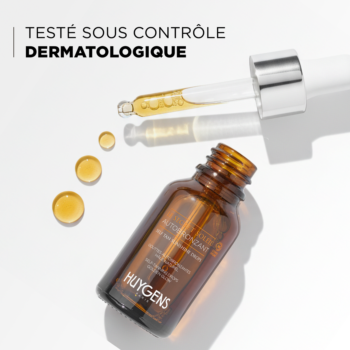 Flacon ouvert et gouttes dorées, testé sous contrôle dermatologique